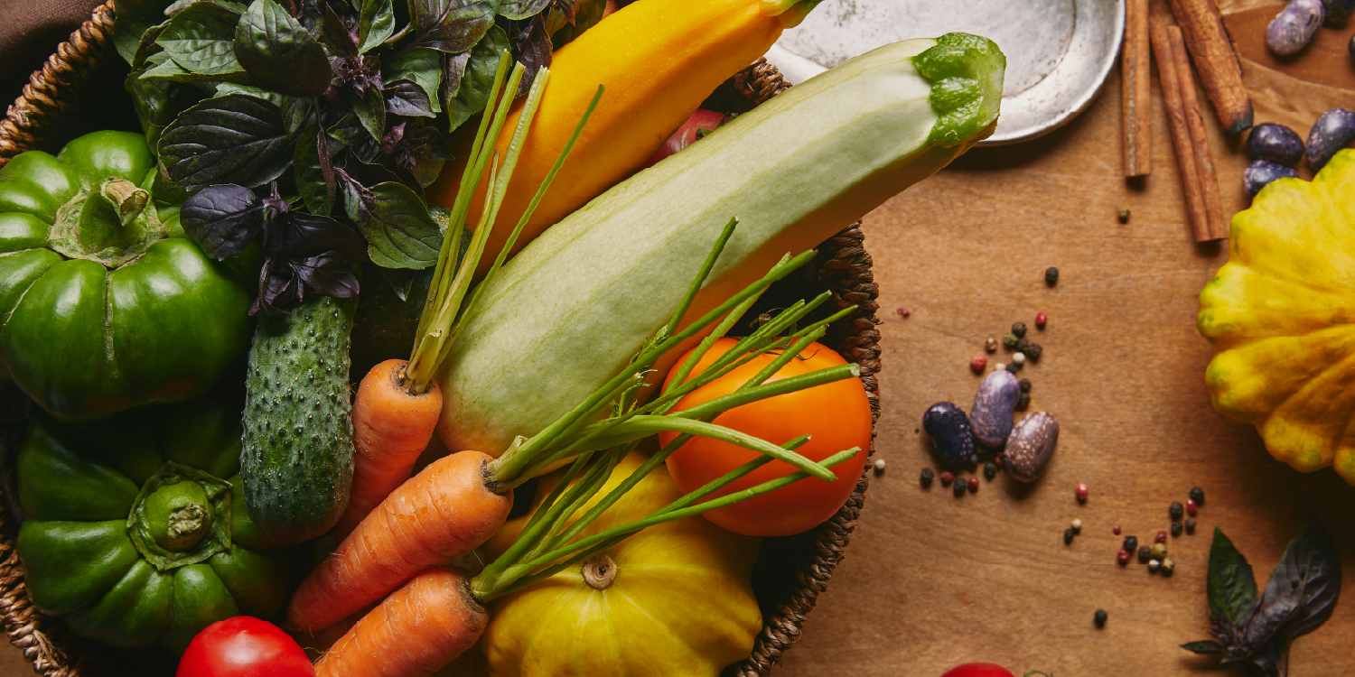 Cesto com legumes frescos, como pimentos, curgete e cenouras