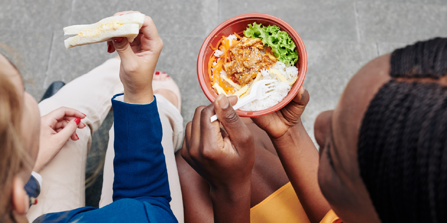 Amigos a comer, vistos de cima, com uma taça de comida e uma sandes