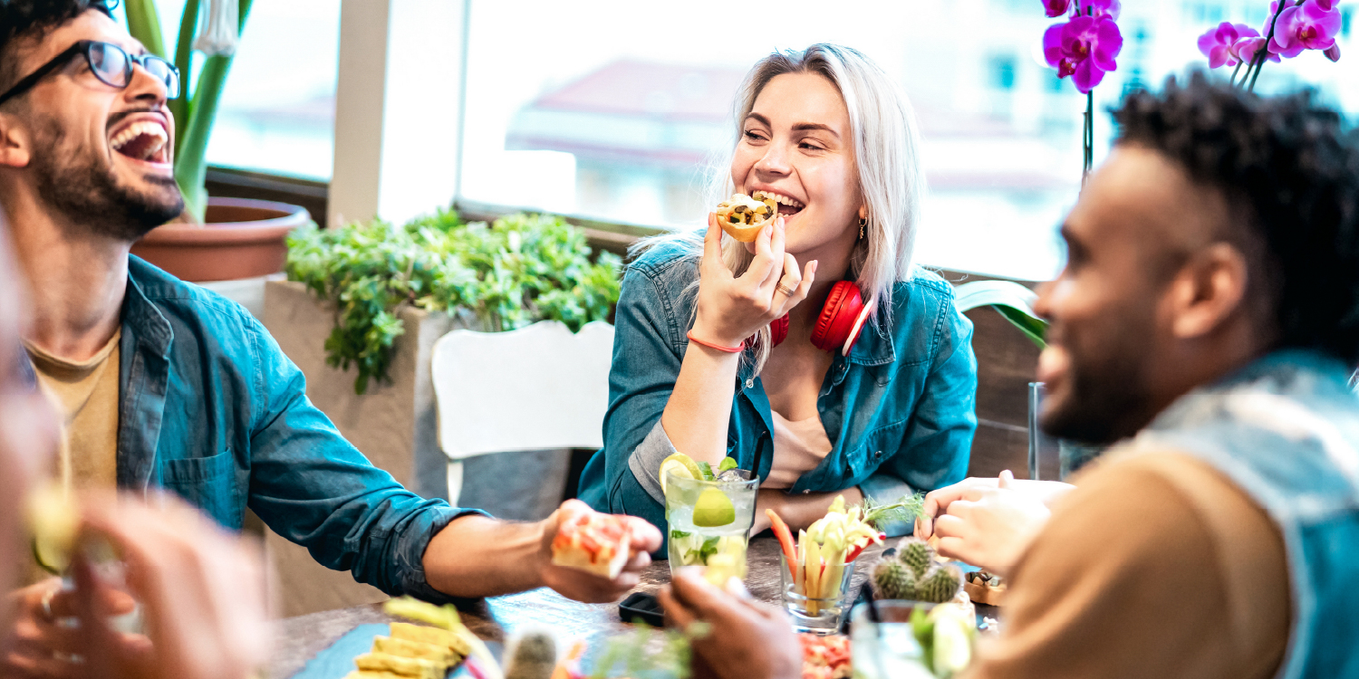 Amigos a comer e a conversar à mesa de um café